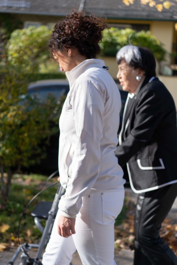 Fachpflegekraft begleitet Patientin beim Spaziergang Fachpflegekraft begleitet Patientin beim Spaziergang